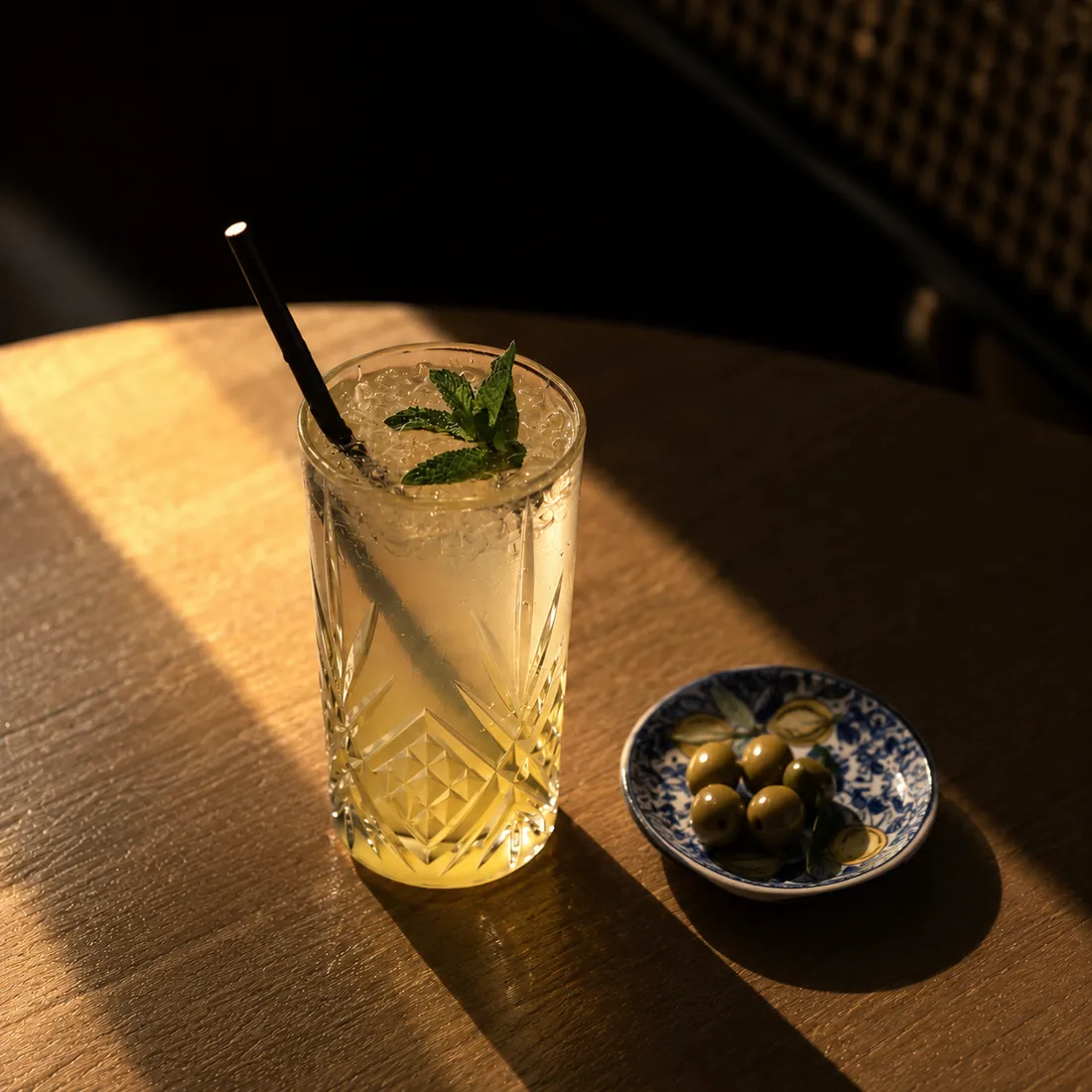Long drink citronné à la menthe, accompagné d'olives