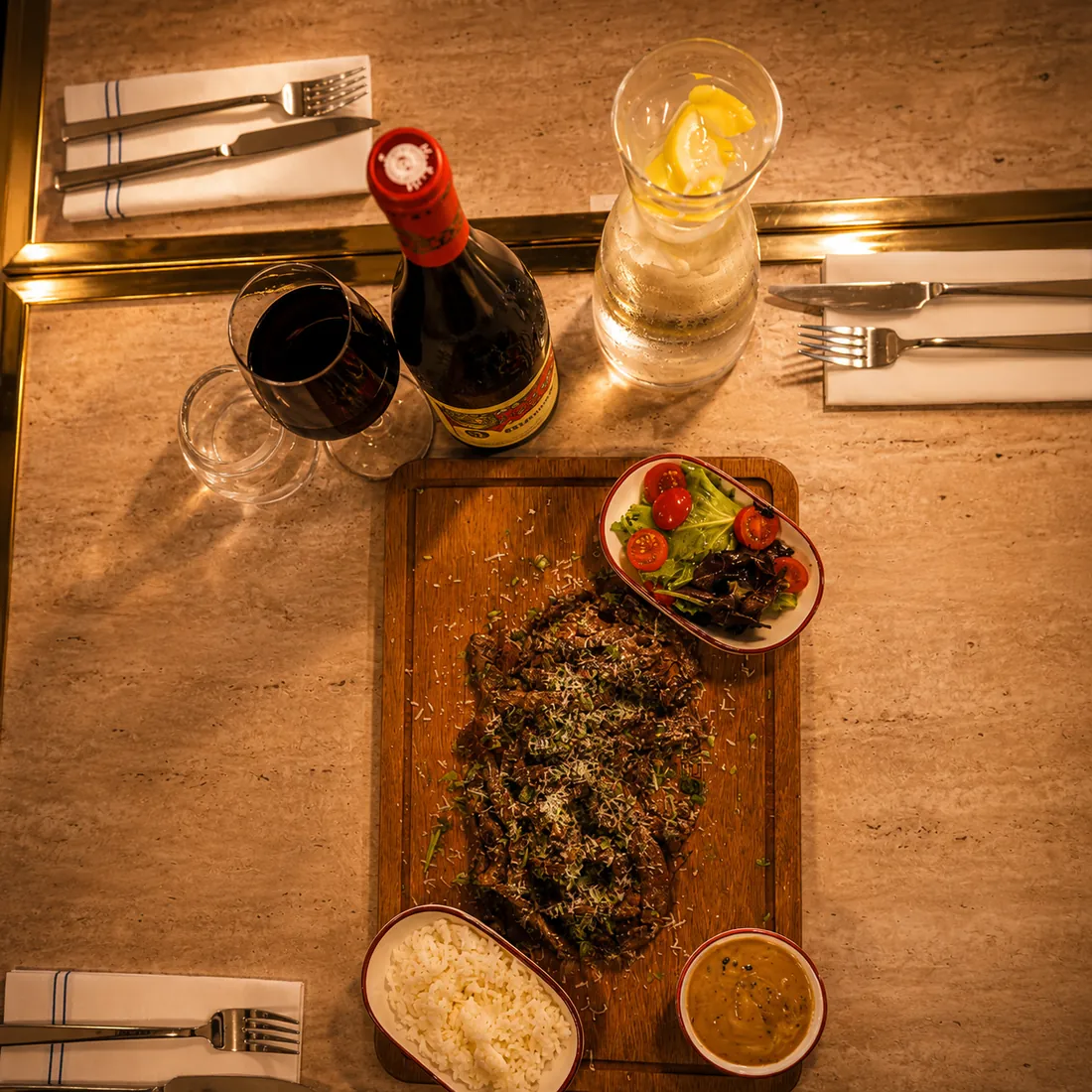 Pièce de viande à la croûte d'herbes sur planche, riz et sauce