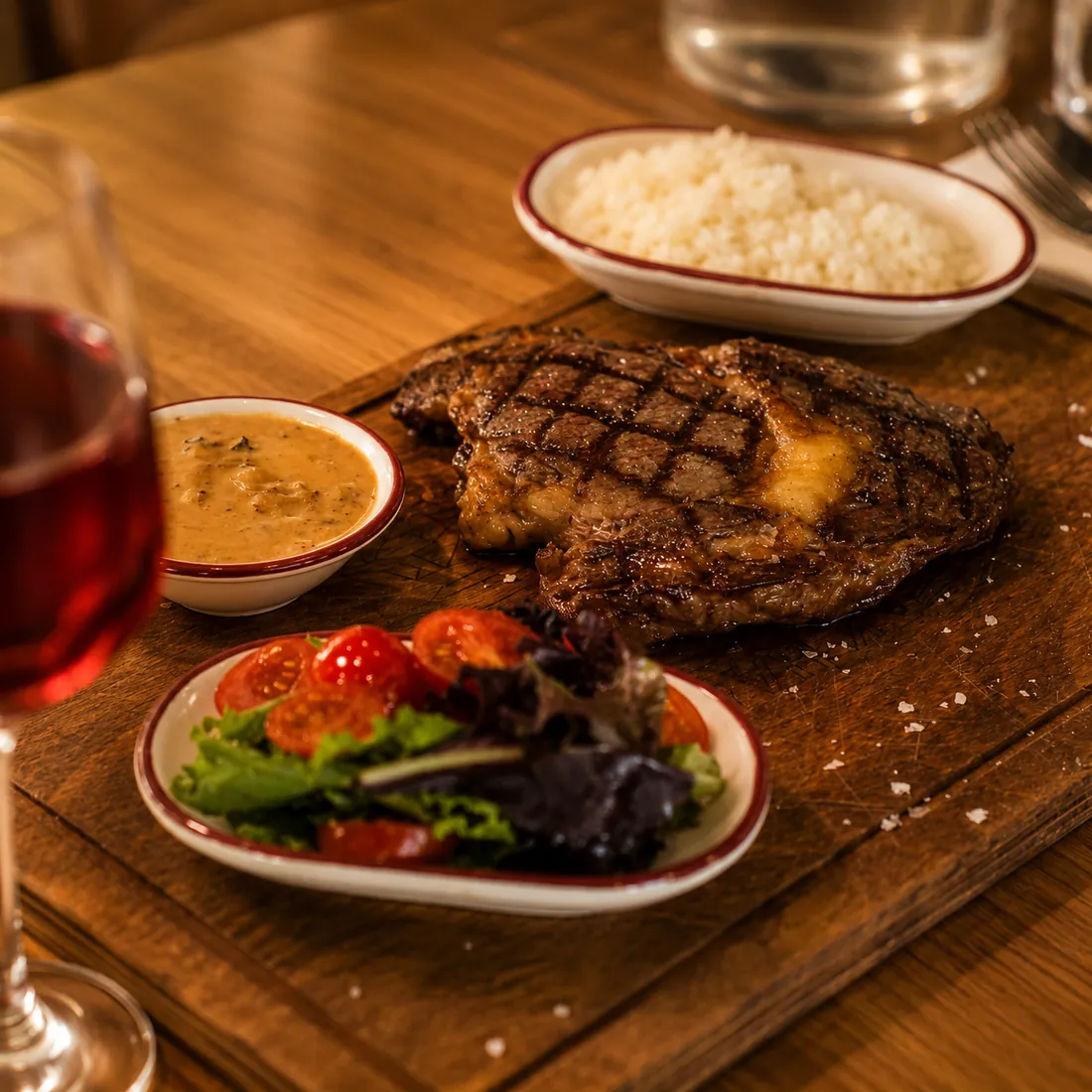 Pièce de bœuf persillée grillée, sauce, riz et salade fraîche