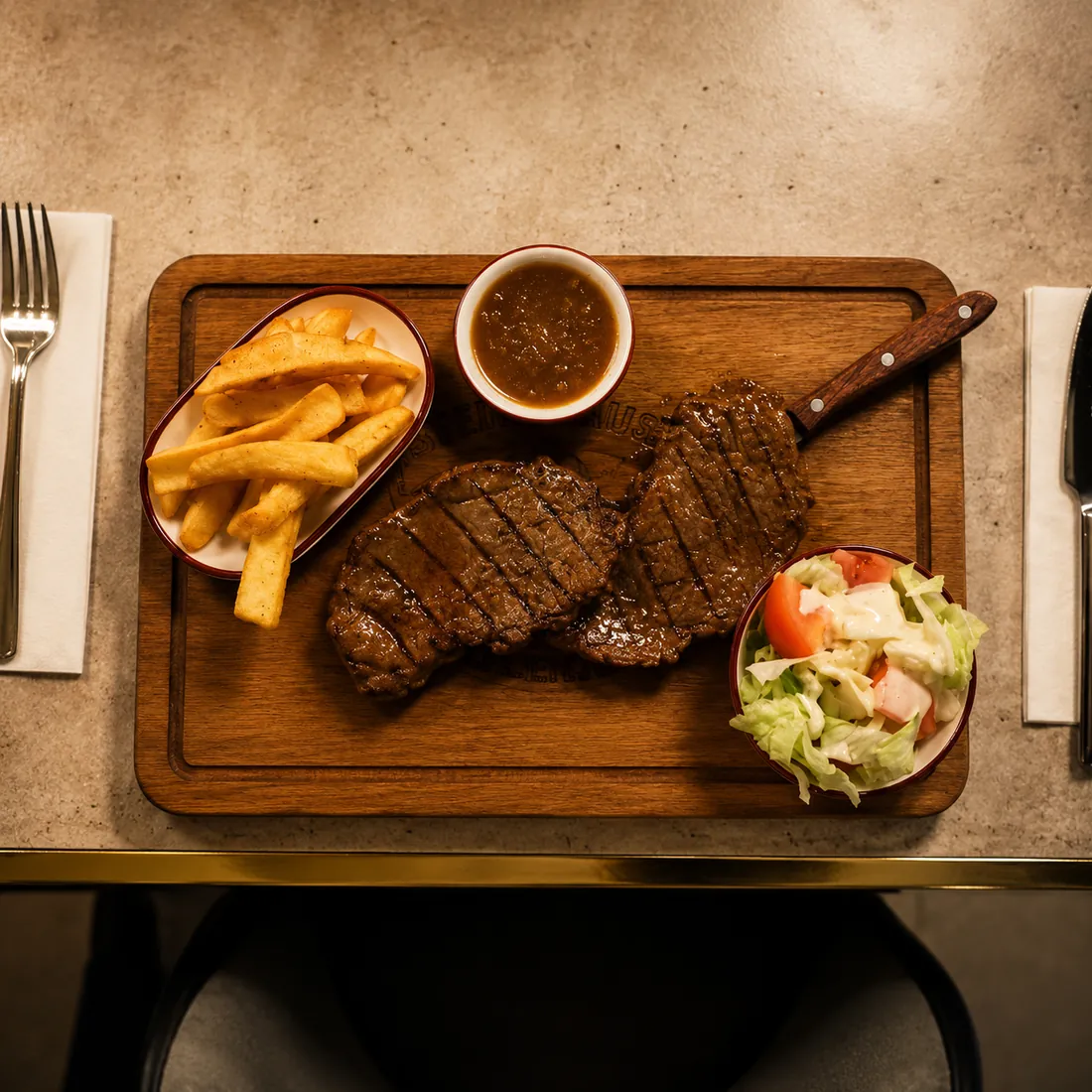 Deux steaks grillés avec frites, sauce et salade